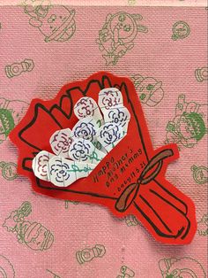 a red and white brochure with flowers in it on a pink table cloth