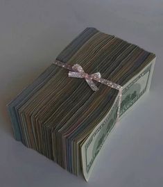 a stack of money with a bow on it's end is wrapped in ribbon