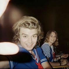 two people sitting at a table with drinks in front of them