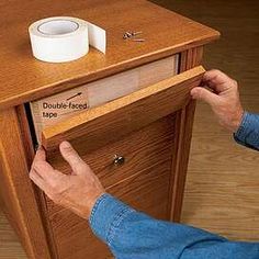 a person is opening a drawer with a roll of toilet paper on the top and bottom