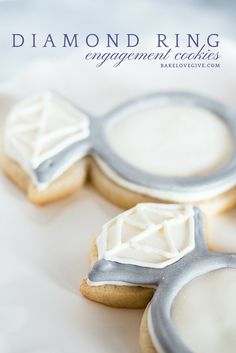 three decorated cookies sitting on top of a white plate with the words diamond ring engagement cookies