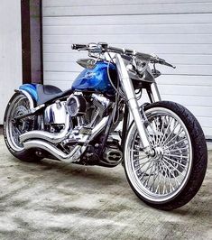 a blue motorcycle parked in front of a garage door