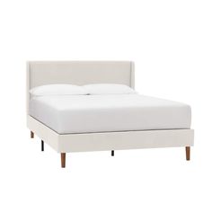 the bed is made up with white linens and wood legs, but it has no headboard