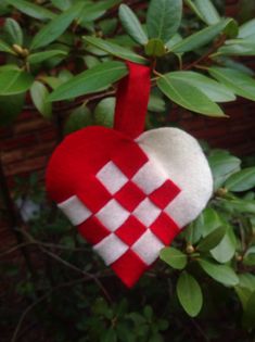 a red and white heart hanging from a tree