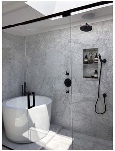 a white bath tub sitting next to a walk in shower