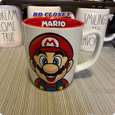 two coffee mugs with mario on them sitting on a table next to each other