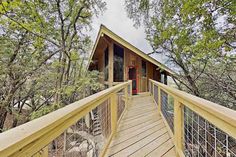 a wooden walkway leading to a cabin in the woods