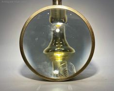 an antique looking glass vase is shown through a magnifying glass dome on a white surface