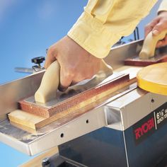 a person using a machine to cut wood