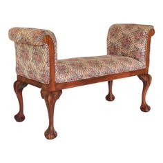 an ornate wooden bench with floral upholstered fabric on it's armrests