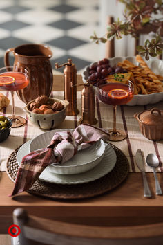 a table set with plates, silverware and wine glasses