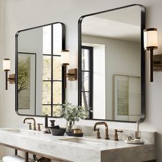 a bathroom with two sinks and mirrors on the wall