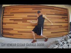 a man standing in front of a wooden garage door with the words diy veneer cedar garage door