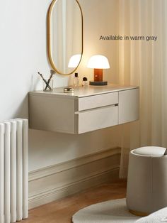 a white table with a mirror and lamp on it next to a radiator