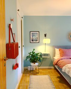 a bed room with a neatly made bed and a potted plant