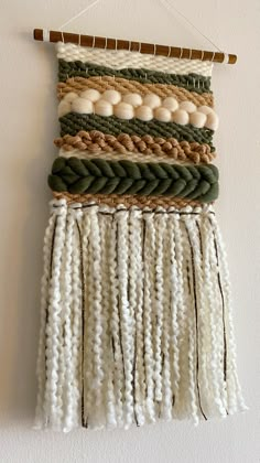 a wall hanging made out of white and green beads