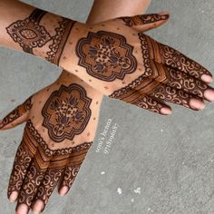 two hands with henna designs on them