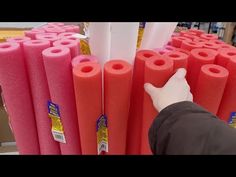 a person is pointing at some pink rolls