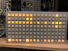 an electronic device with many yellow squares on the front and back sides, sitting on a table