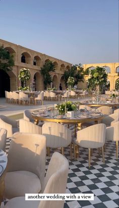 an outdoor dining area with white chairs and tables