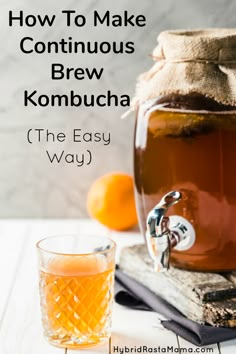 a bottle of kombucha next to an old fashioned glass and oranges