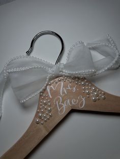 a wooden hanger with a white bow on it