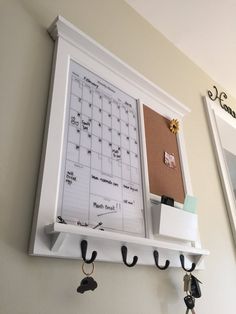 a bulletin board and key hooks are hanging on the wall next to each other in a home office