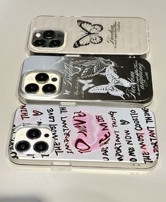 three cell phones sitting next to each other on top of a white table with black and pink designs