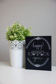 a happy birthday card next to a potted plant