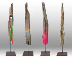 five different types of wooden sculptures on metal bases with colored paint and wood sticks sticking out of them