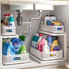 two bins with cleaning products in them on the side of a kitchen sink under a faucet