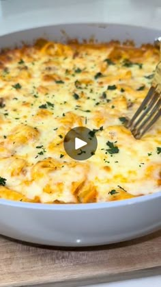 a fork in a casserole dish with cheese and parsley on the side