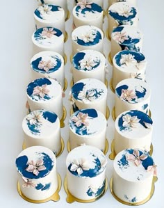 many white and blue decorated cakes with gold trim