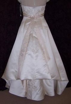 a white wedding dress is displayed on a mannequin