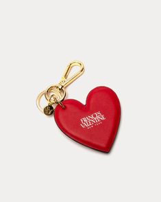 a red heart shaped keychain with the words maker waiting on it