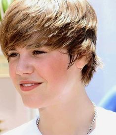 a close up of a person with a necklace on their neck and hair in the background