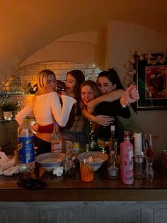 three girls are hugging and having fun in the kitchen