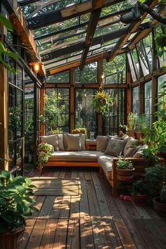 a wooden deck with couches and potted plants in the center, surrounded by greenery