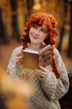 a woman with red hair is reading a book