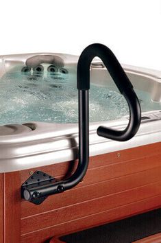 an outdoor hot tub with two people in it and a hand rail attached to the side