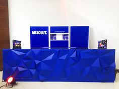 a blue counter sitting in front of a white wall with three televisions on it