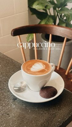 a cappuccino sits on a saucer next to a cup of coffee