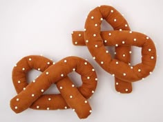 two knitted pretzels with white polka dots on them sitting side by side