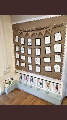 a bulletin board with pictures on it and some lights hanging from the wall behind it