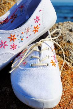 a pair of white shoes sitting on top of a rock