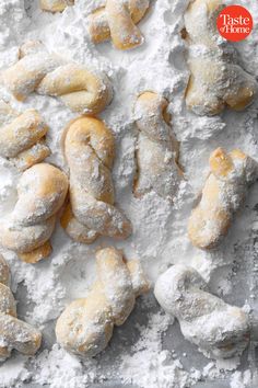 powdered doughnuts and pastries on a baking sheet covered in powdered sugar