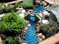 a wooden box filled with lots of rocks and plants