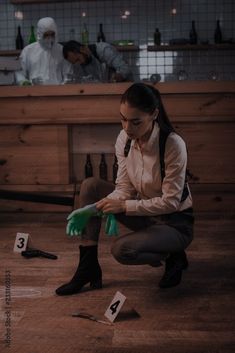 a woman kneeling down on the floor with green gloves