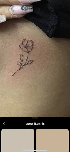 a woman's stomach with a small flower tattoo on her side ribcage