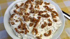 a white bowl filled with food on top of a checkered tablecloth covered table